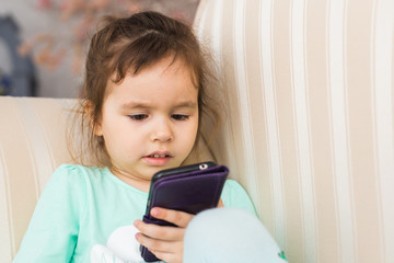 Cute little girl using modern smartphone