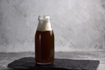 coffee beverage in a glass bottle on a black stone plate