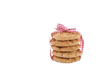 Stack of healthy vegan integral cookies made of hazelnut powder & linseed tied with bow isolated on white background. Home made vegetarian sugarless & gluten free snack with nuts. Close up, copy space