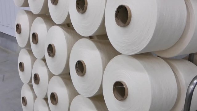 Spools of thread, close-up. Factory of production of cotton threads. the camera is in motion