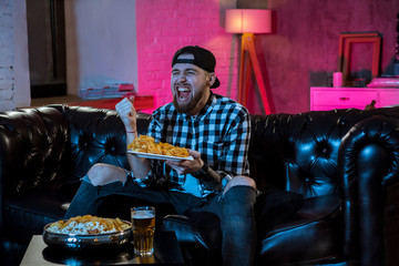 Happy man watching TV and cheering at night