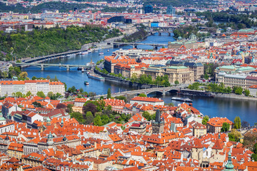 Obraz premium Aerial view of old Red Tiles roofs in the city Prague, Czech Republic, Europe. Beautiful day with blue sky with clouds in the town.