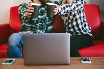 Couple sitting on red couch drinking coffee