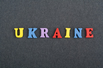 UKRAINIAN word on black board background composed from colorful abc alphabet block wooden letters, copy space for ad text. Learning english concept.