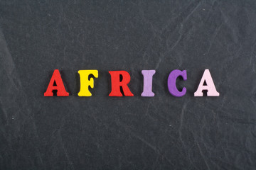 AFRICA word on black board background composed from colorful abc alphabet block wooden letters, copy space for ad text. Learning english concept.