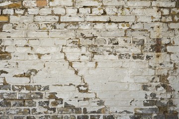 Weathered old brick wall with white paint