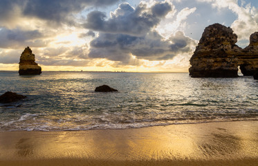 beautiful Atlantic ocean view horizon with sandy beach, rocks and waves at sunrise