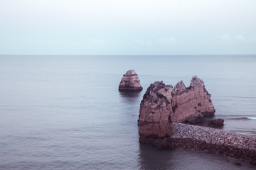 beautiful Atlantic ocean view horizon with sandy beach, rocks and waves at sunrise