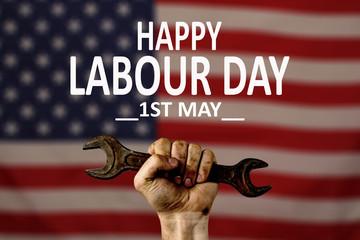 Male hand worker holding wrench, on American flag background, isolate. With an inscription, happy labour day. International celebration.