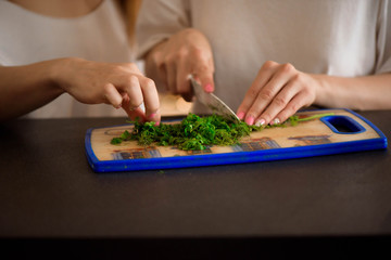 Young sisters making vegetable salad at home