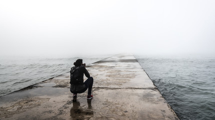 Photographer on a misty pier.