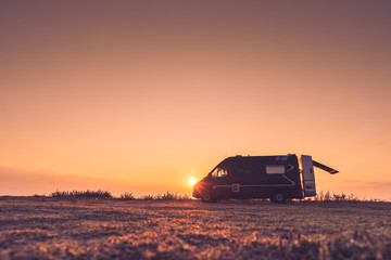 Camper car on nature at sunrise