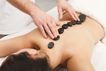 Obraz na płótnie Canvas Woman getting hot stones massage at spa salon
