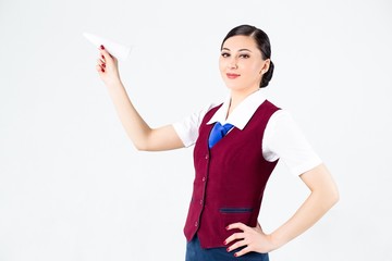 Flight attendant in a red vest holding a paper airplane