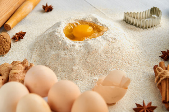Ingredients for baking cake and accessories on the gray table: rolling pin, eggs, ginger, anise stars, cinnamon and bakewares. Baking background. Side view