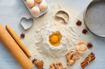 Baking background. Raw igredients for cake (eggs, spices, flour) and bakery supplies. Kitchen table. Top view