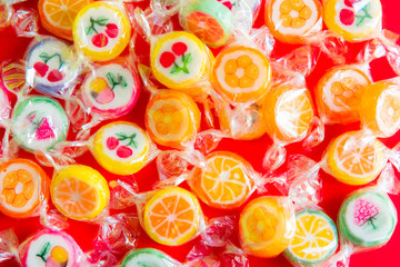 Fototapeta na wymiar Fruit candies on red background