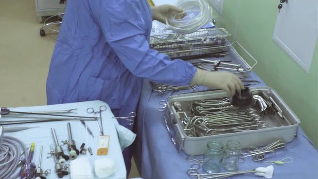 Surgical nurse preparing medical instrument for operation
