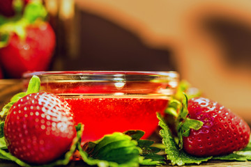 Fresh strawberries with leaves and jam close
