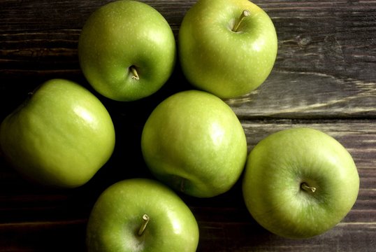 Green apples on a wood board