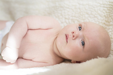 Portrait of a newborn baby lying on his side