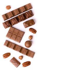 Chocolates of different shapes on a white background, top view.