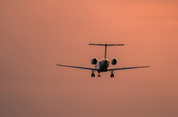 Airplane landing at sunset