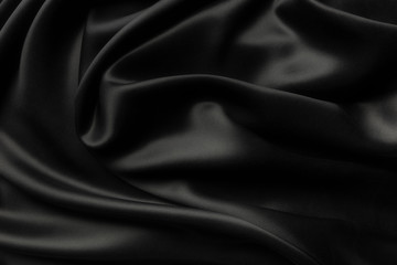 Elegant black satin silk with waves, abstract background.
