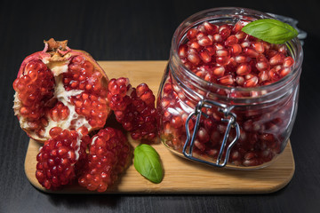 Ripe pomegranate fruit in a jar on wooden vintage background