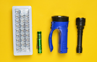 Lots of flashlights on a yellow background, top view.