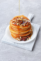 Tasty breakfast. Homemade pancakes with crushed hazelnut pouring honey or maple syrup