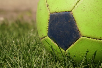 Fototapeta na wymiar Old Football Or Soccer Ball On The Grass Close Up