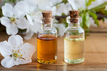 Bottles of essential oil with white cherry blossoms