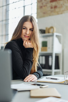 Young businesswoman sitting reading her monitor