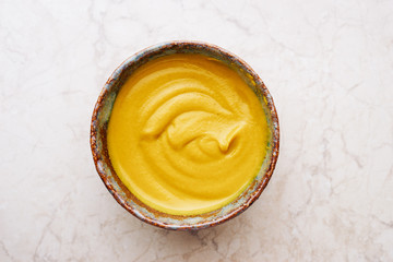 Delicious homemade English mustard in bowl top view