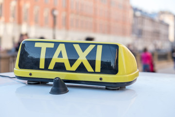Taxi text on black background sign on taxi cab roof