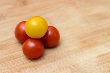 Ripe red and yellow tomatoes on a wooden background. Concept of healthy food.