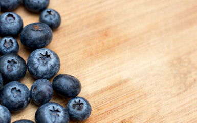 Ripe Blueberry close-up on wooden background with open space on one side