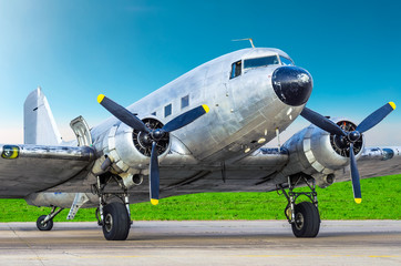 Fototapeta premium Turbo-prop vintage airplane parked at the airport, shiny metal fuselage aircraft.