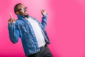 Surprised African man with glasses leaned back standing on pink