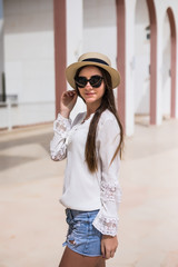 Beautiful young woman walking in the city in summer time on sea resort