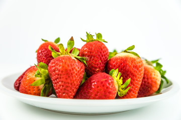 strawberries in white porcelain dish with white background