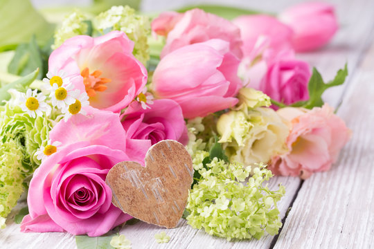 Pink flower bouquet on rustic wooden background