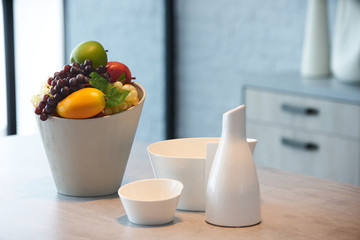 Fototapeta na wymiar Beautiful modern kitchen interior with kitchenware and fresh fruit bowl on countertop, close-up