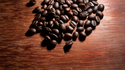 Coffee beans on wood texture background.