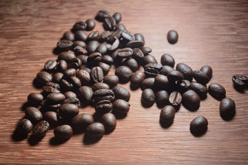 Coffee beans on wood texture background.