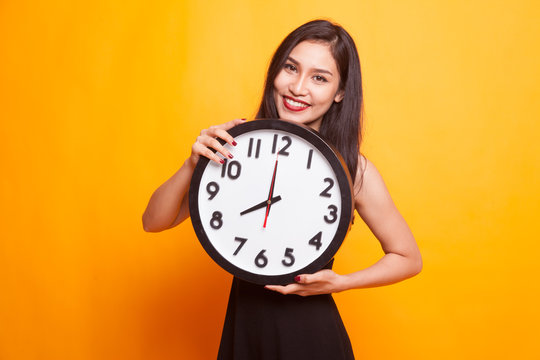 Happy Young Asian woman with a clock.