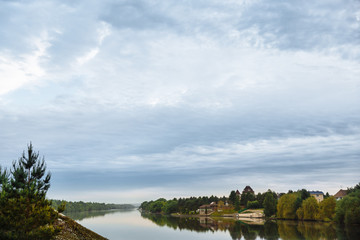 Fototapeta premium Beautiful landscape with river and gloomy sky. Sunrise