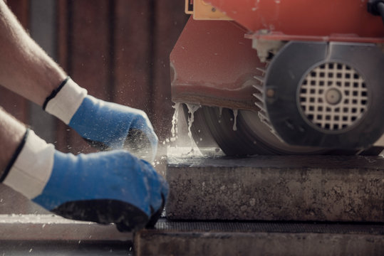 Retro image of workman using an angle grinder or circular saw to cut a concrete block