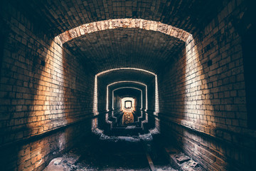 Ruined brick underground tunnel or corridor and light in end, abstract way to hope or escape to...